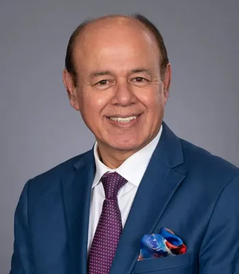 Professional headshot of Dr. Vohra in blue suit with maroon tie
